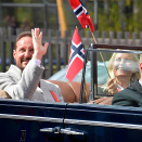 Kronprinsparet vinker til folk på balkonger og i vinduer under kjøreturen i Asker. Foto: Liv Anette Luane, Det kongelige hoff